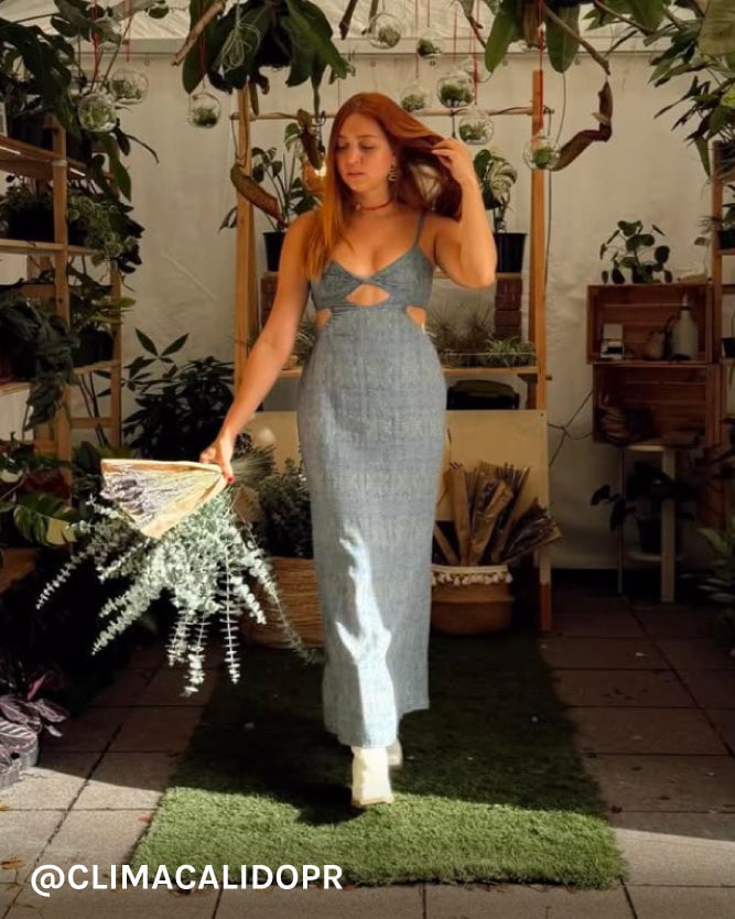 Woman in a maxi dress standing in a plant-filled indoor setting